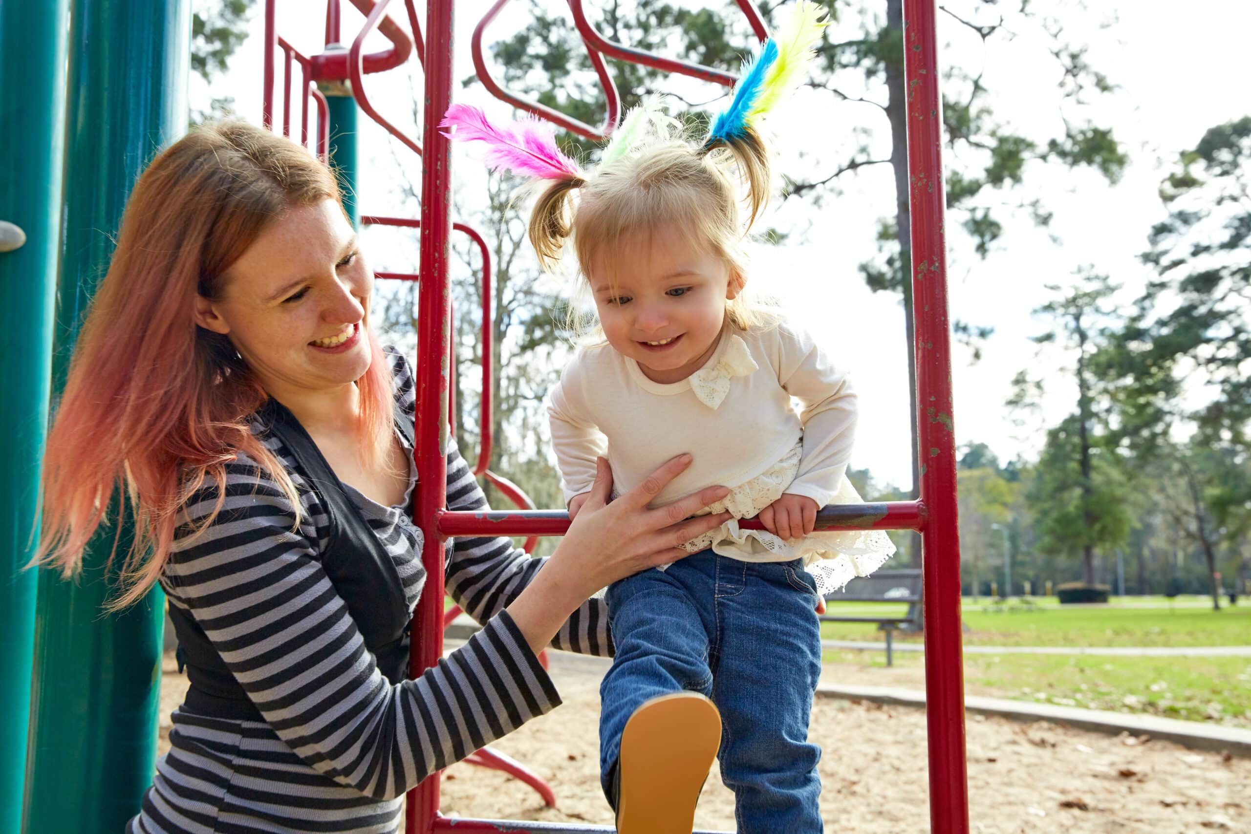 A mother practicing speech therapy strategies with her daughter at the playground.