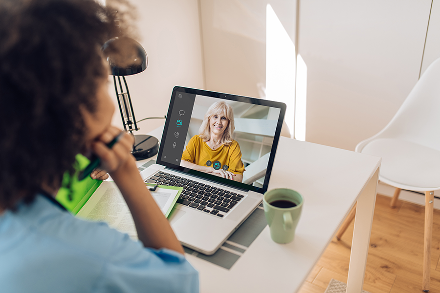 A parent speaking to a speech therapist through a virtual session on the computer.