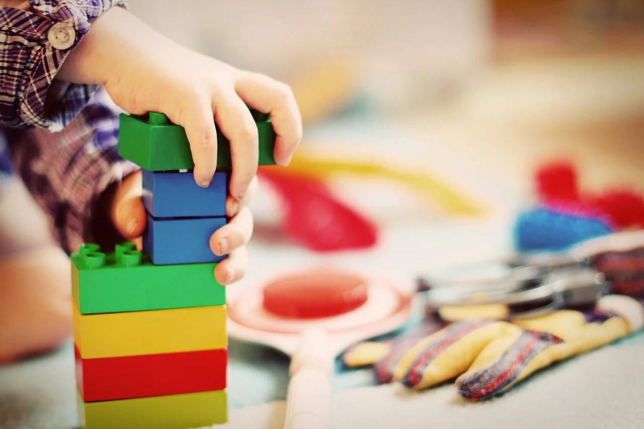 A child plays with blocks during speech therapy.