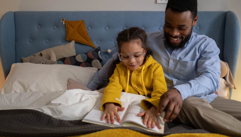 A parent reading to his child so that she learns more new words.
