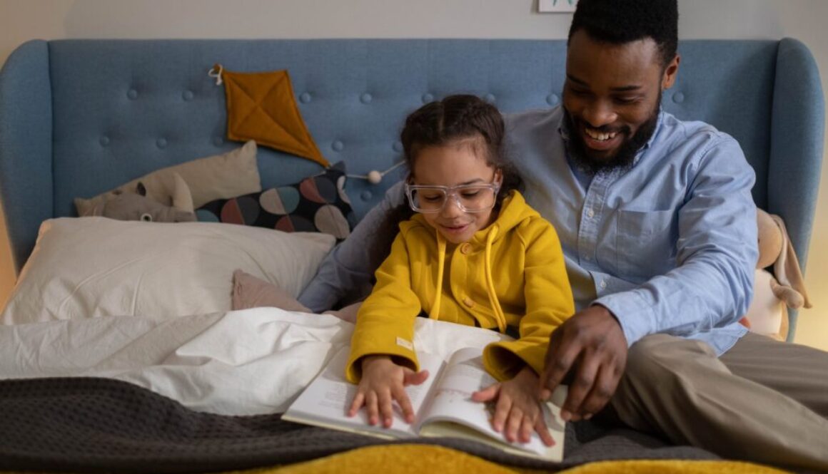 A parent reading to his child so that she learns more new words.
