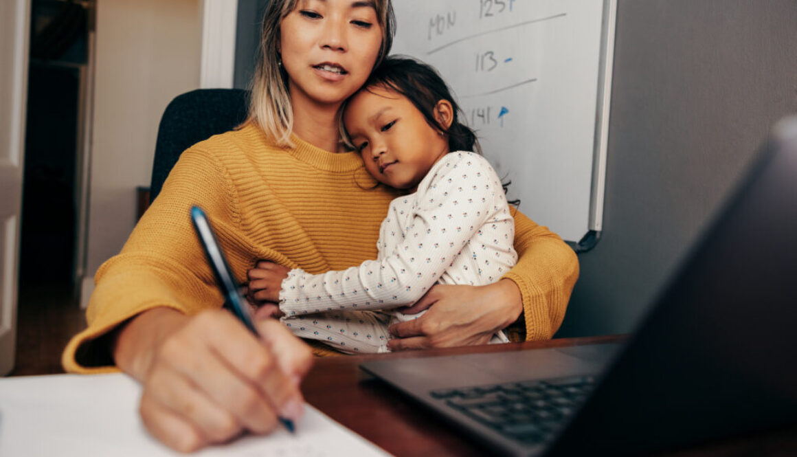 A mother talking to a speech therapist and taking notes.