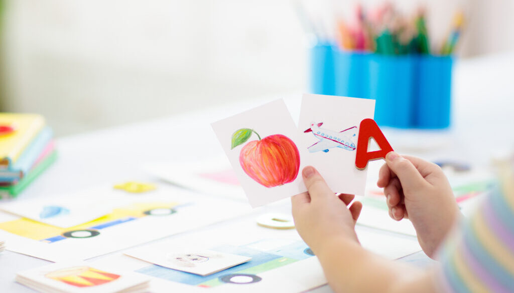 A child playing and practicing words during early language learning.
