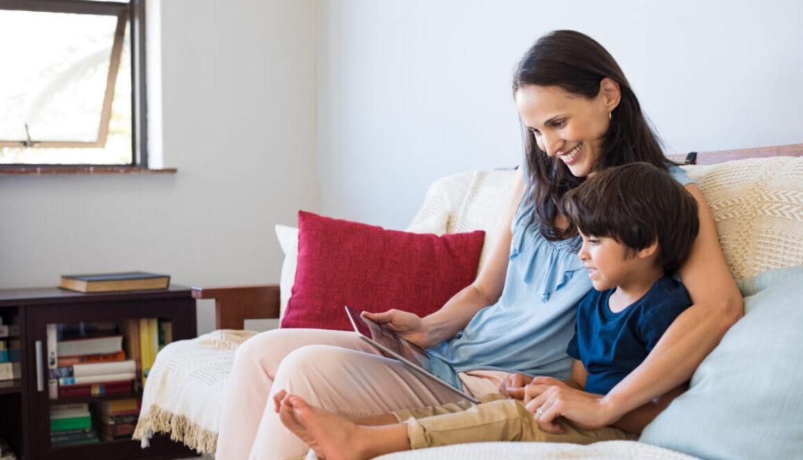 A mother practicing better language skills with her son using iPAD games.